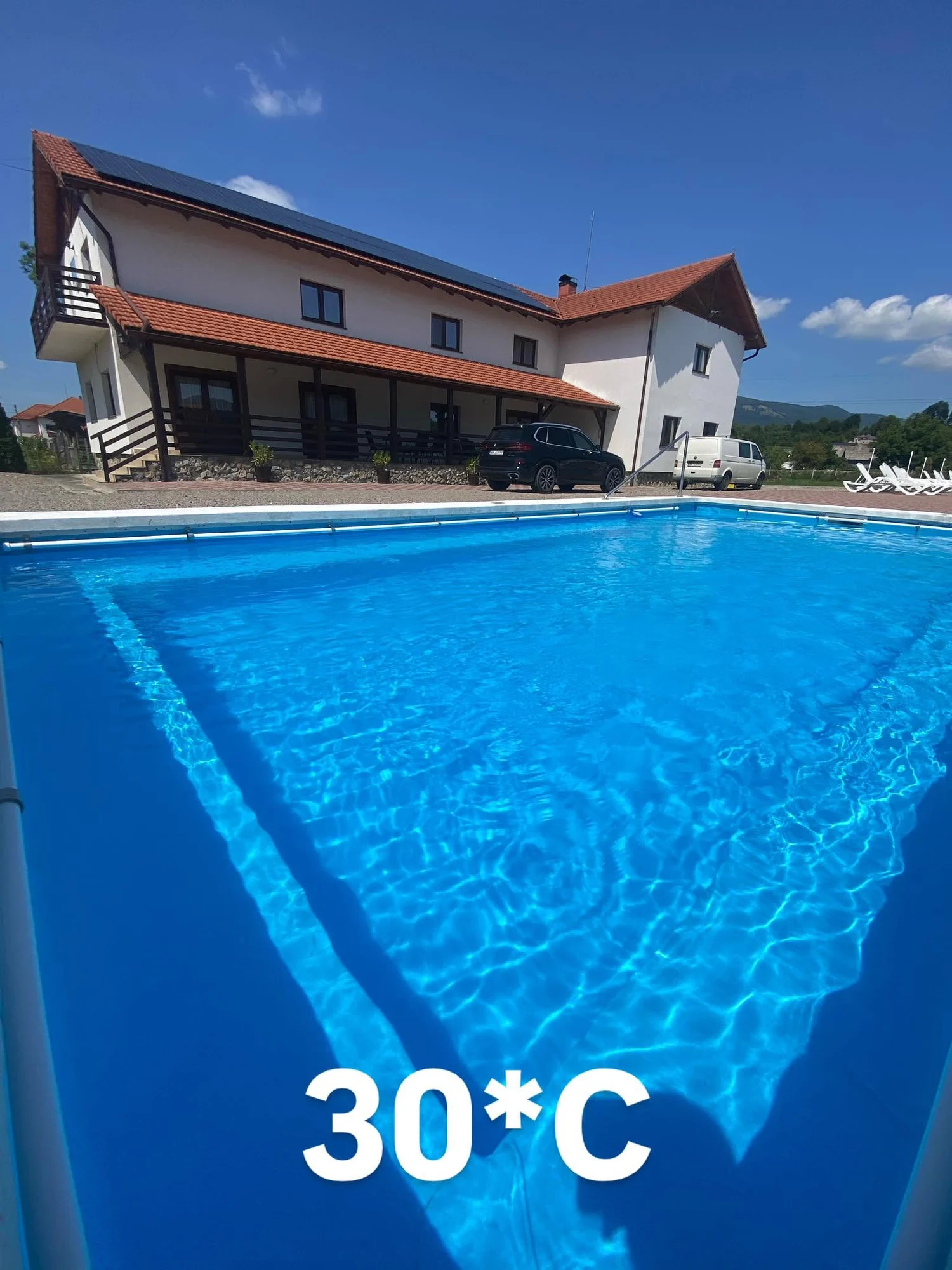 Pensiunea Ony și piscina exterioară într-o zi senină